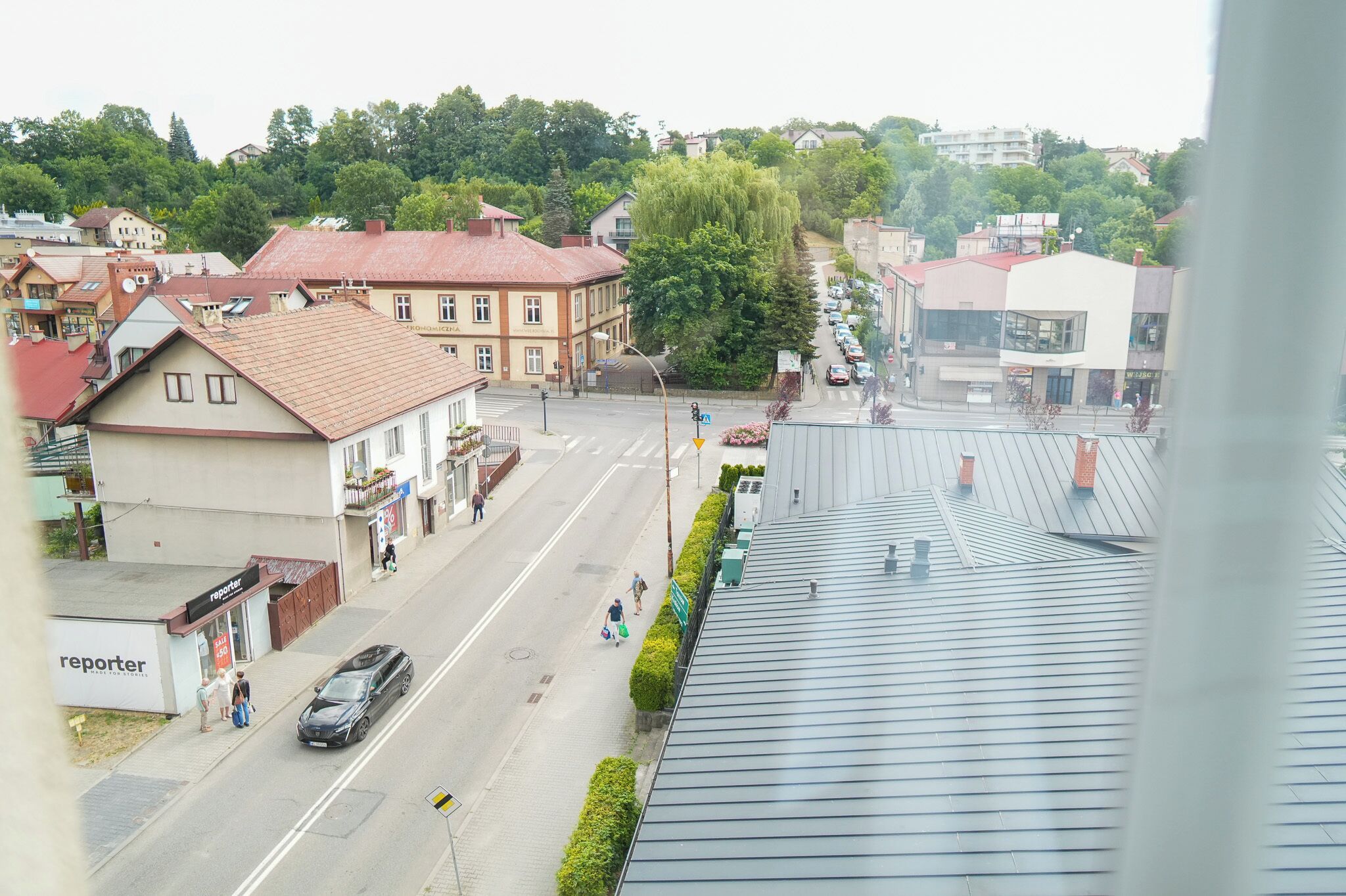 A street view with buildings, a clear road, and a pedestrian crossing.