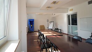 A conference room with a long table, chairs, a whiteboard, and a projector. - Hotel Sutoris (Bochnia)