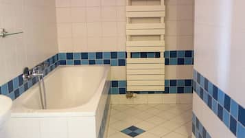 A bathroom with a bathtub, a shower, and a toilet.