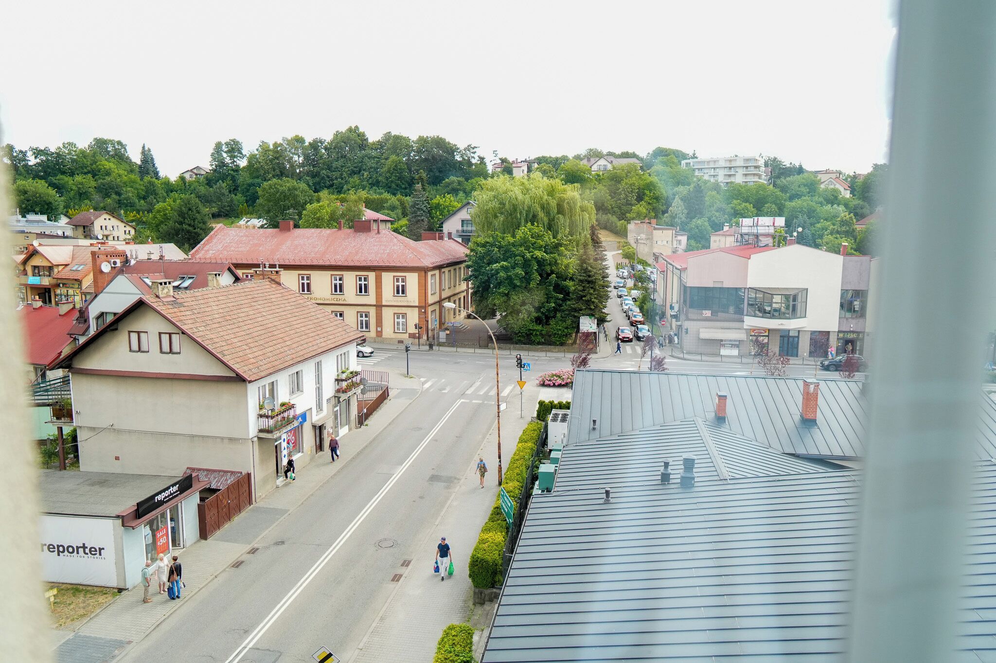 A street view with buildings, a clear sky, and a pedestrian crossing.