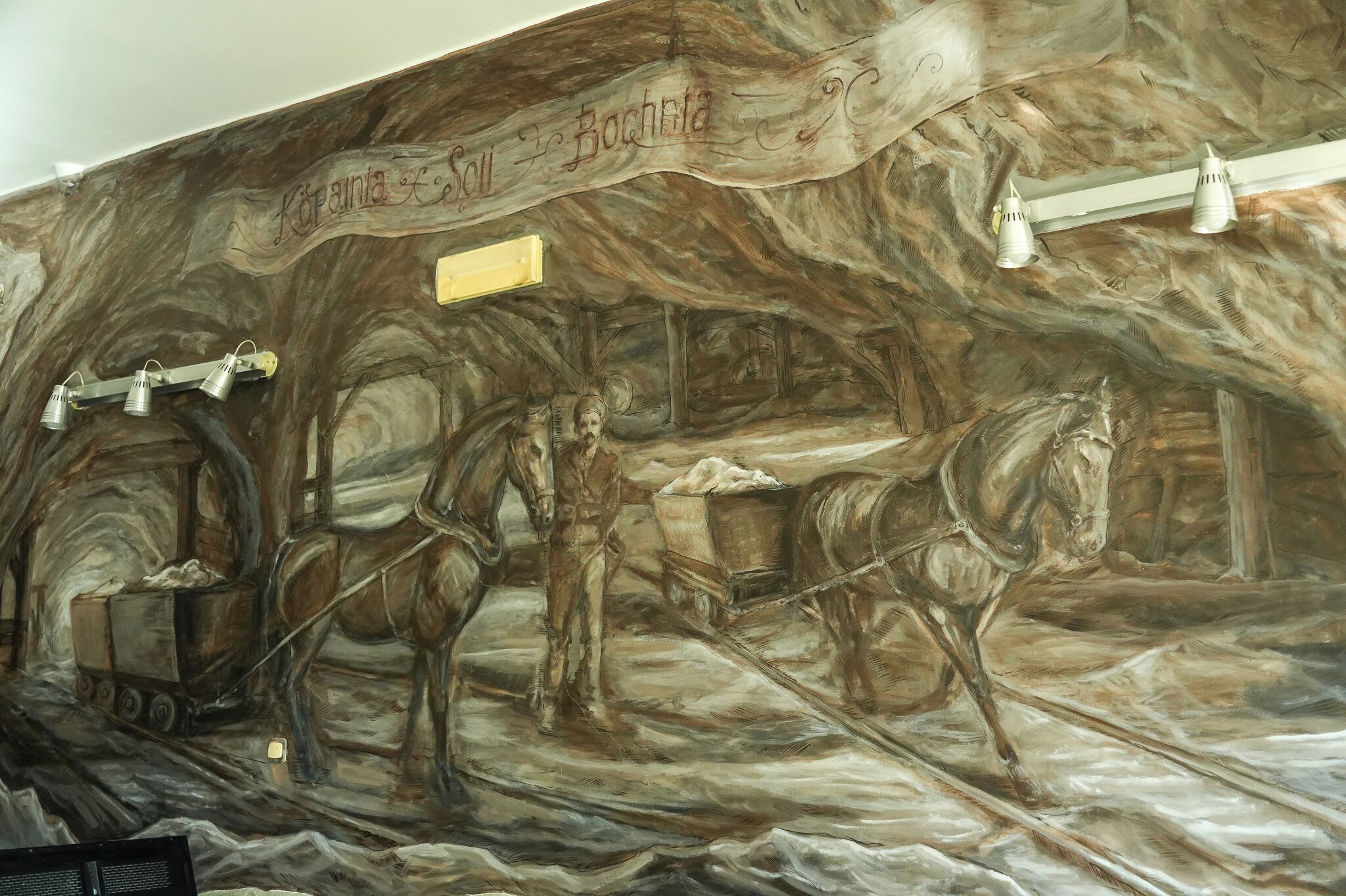 A mural with a horse-drawn cart and a person, possibly in a historical setting.