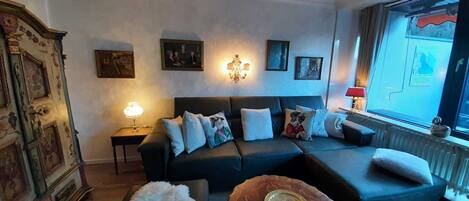 A living room with a sofa, a coffee table, a lamp, and a radiator.
