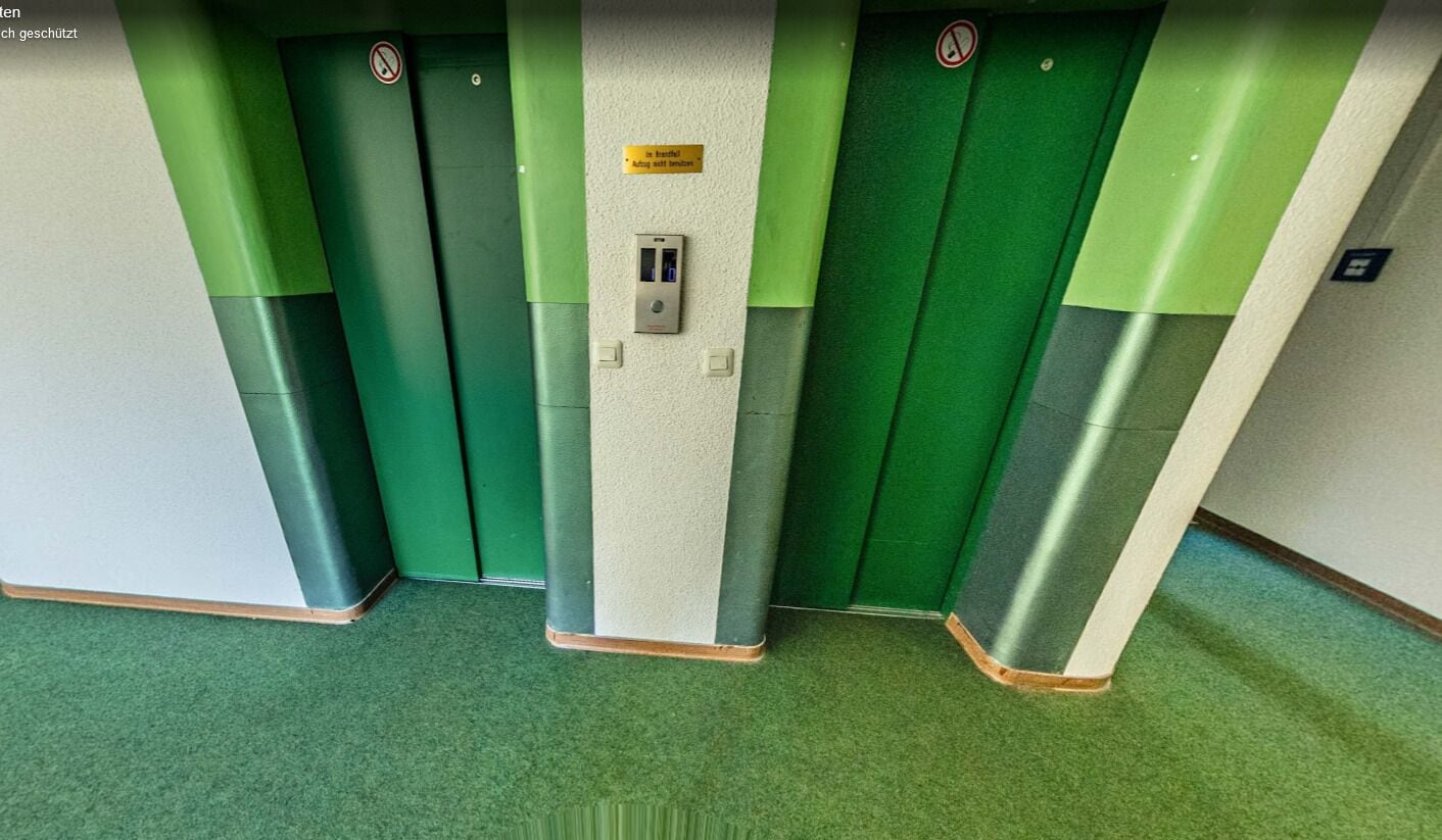 A set of green and white elevator doors with a control panel and a sign indicating the elevator is out of service.
