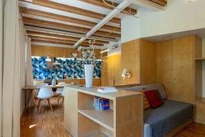 A compact living space with a kitchenette, a dining area, and a seating area with a sofa and cushions. - Your ideal urban retreat in Barcelona. This apartment combines functional design with an unbeatable location next to Ciutadella Park and the 22@ district. Featuring two full bathrooms and high-speed Wi-Fi, it offers everything you need for a comfortable  (Barcelona)