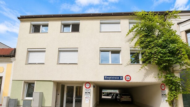 Un edificio con un letrero que dice 'Hauptstrasse 18' y un cartel de no estacionamiento.