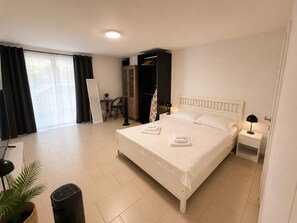 A hotel room with a bed, bedside table, and a small table with chairs.
