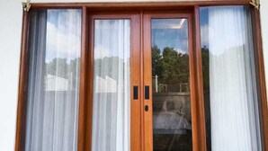A set of wooden sliding doors with glass panels and curtains.