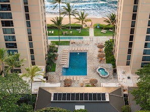 A rooftop pool with lounge chairs, a small hot tub, and a view of the beach. - Oceanfront Retreat with Panoramic Views & Beachfront Lanai -Mahana (Lahaina)