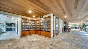 Un vestíbulo amplio con piso de espiga, estanterías de madera y techo con vigas de madera.