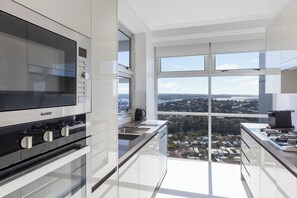 Eine moderne Küche mit einem BLANCO Herd, großen Fenstern und Blick auf die Stadt.