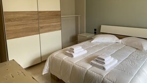 A bedroom with a bed, a wardrobe, and a nightstand. - Beach View House with Private Garden (ΧΑΛΚΙΔΑ)