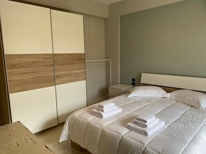 Ein Schlafzimmer mit einem Bett, einem Kleiderschrank und einem Nachttisch.