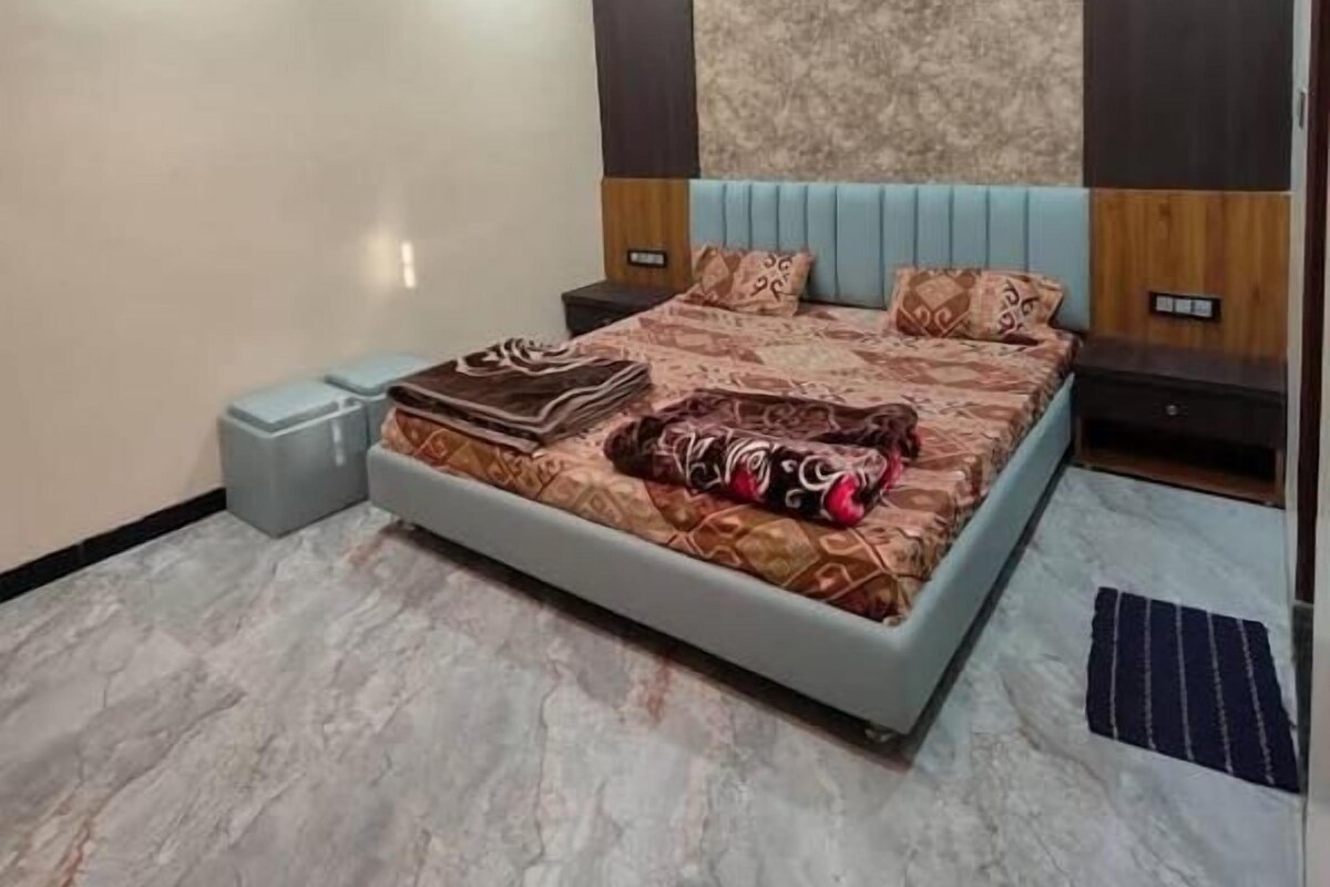 Un dormitorio con cama, ventilador de techo y mesita de noche.
