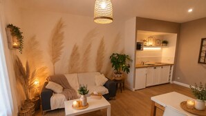 Un salon confortable avec un canapé, une table basse et un coin repas comprenant une chaise.