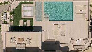 An aerial view of a rooftop pool area with lounge chairs, a sunbed, and a small garden. - Norma Villa, Heated Pool, Walk to Shops & Dining (Rethymno)