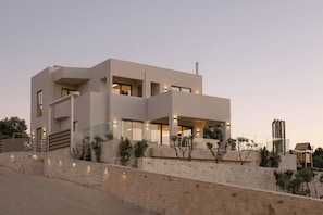 A modern multi-story building with a stone facade, large windows, and a staircase leading to the upper levels. - Norma Villa, Heated Pool, Walk to Shops & Dining (Rethymno)