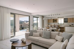 Ein modernes Wohnzimmer mit einer Couch, einem Esstisch und einer Küchenzeile.