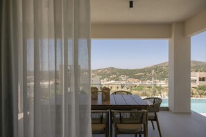 A balcony with a table and chairs, overlooking a mountainous landscape. - Norma Villa, Heated Pool, Walk to Shops & Dining (Rethymno)
