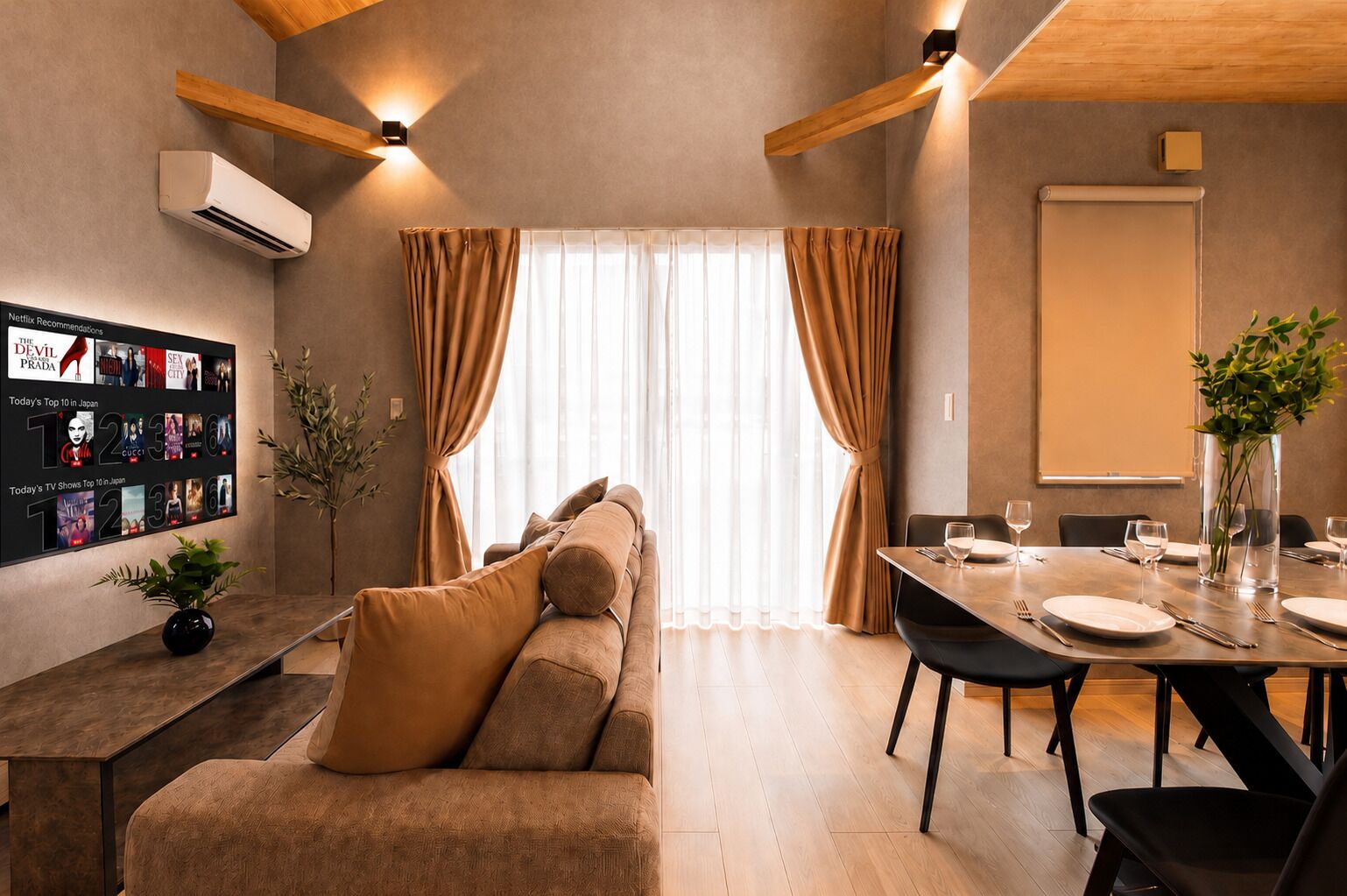A modern living room with a sofa, a dining table set for two, and a wall-mounted TV displaying Netflix recommendations.