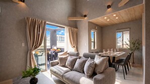 A modern living room with a sofa, dining table, and large windows. - Fuji Terrace -EIRAN- (Gotemba)
