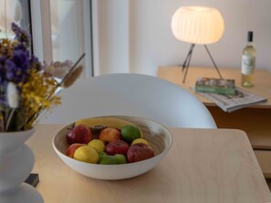 A bowl of fruit on a table with a lamp and a bottle in the background. - Gletschergarten Vacation Rental (Auerbach)