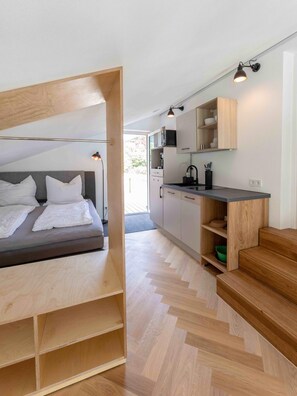 Une chambre moderne dotée d’un bureau intégré et d’un coin cuisine séparé.