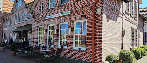 Un bâtiment en briques sur lequel est apposée une enseigne indiquant qu’il propose une cuisine philippine, espagnole et mexicaine.