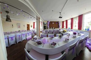A banquet hall with round tables, white tablecloths, and purple sashes. - Tropicana Lüneburger Hof (Munster im Heidekreis)
