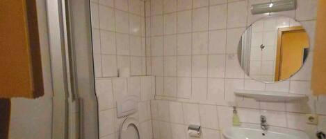A bathroom with a toilet, sink, and shower.