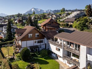 A residential area with houses, a mountain in the background, and a clear sky.