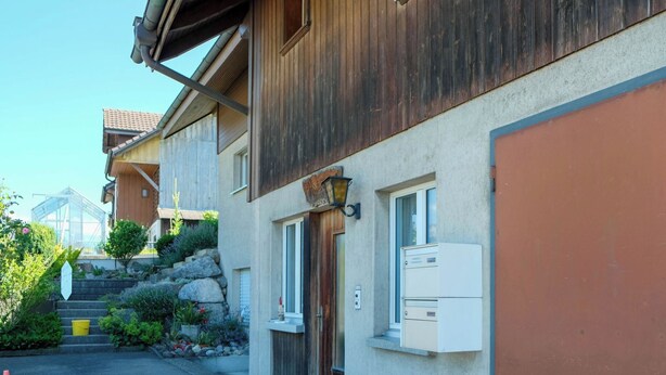 A residential building with a wooden facade, a stone staircase, and a small garden area. - Hauswurz Appartement/Fewo Appartement/Fewo by Interhome (Gwatt (Thun))
