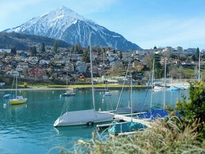 Ein Yachthafen mit Booten, im Hintergrund ein Berg und eine Stadt mit Häusern.