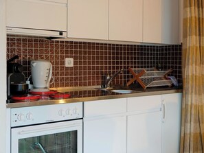 A kitchen with a coffee machine, a kettle, and a toaster on the countertop. - Seewohnung 1 Appartement/Fewo, Dusche Appartement/Fewo, Dusche by Interhome (Spiez)