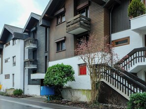 A multi-story residential building with balconies, a staircase, and a small garden area. - Seewohnung 1 Appartement/Fewo, Dusche Appartement/Fewo, Dusche by Interhome (Spiez)