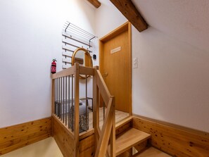 A wooden staircase with a metal railing leading to a door with a nameplate. - Spatzennest Appartement/Fewo Studio by Interhome (Spiez)