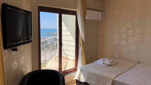 A hotel room with a bed, a TV, a chair, and a balcony with a view. - YUMURTALIK OTEL (Yumurtalık)