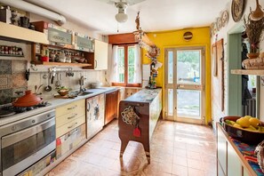 Uma cozinha com fogão, forno e diversos utensílios.