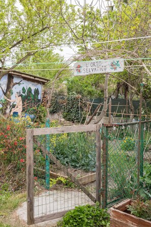 A garden with a wooden gate, a mural, and a sign that reads 'L'ORTO SELVATICO'. - Cà Selvatica - Country home (Nonantola)