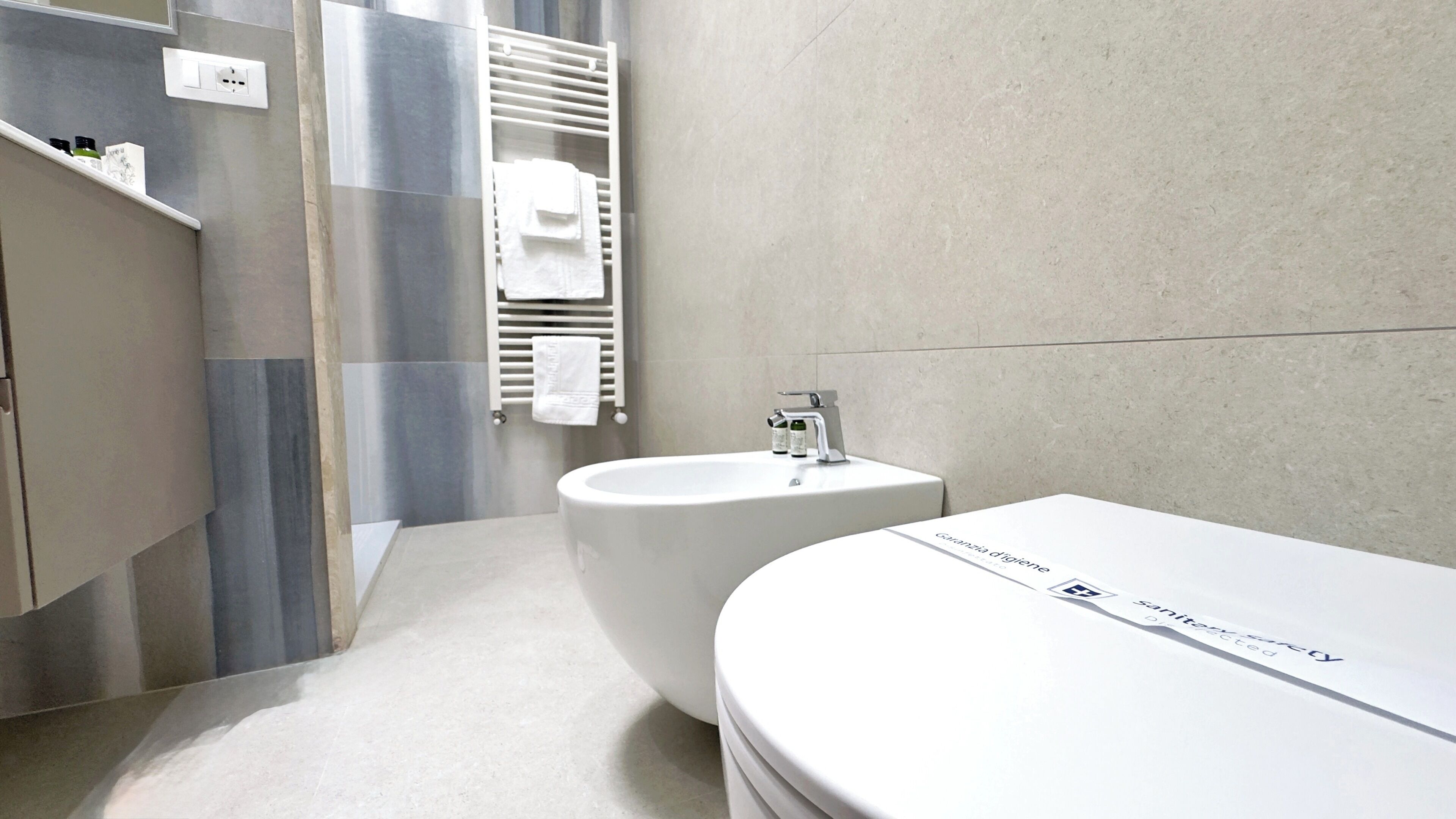 A modern bathroom with a bathtub, a sink, and a towel rack.
