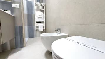 A modern bathroom with a bathtub, a sink, and a towel rack.