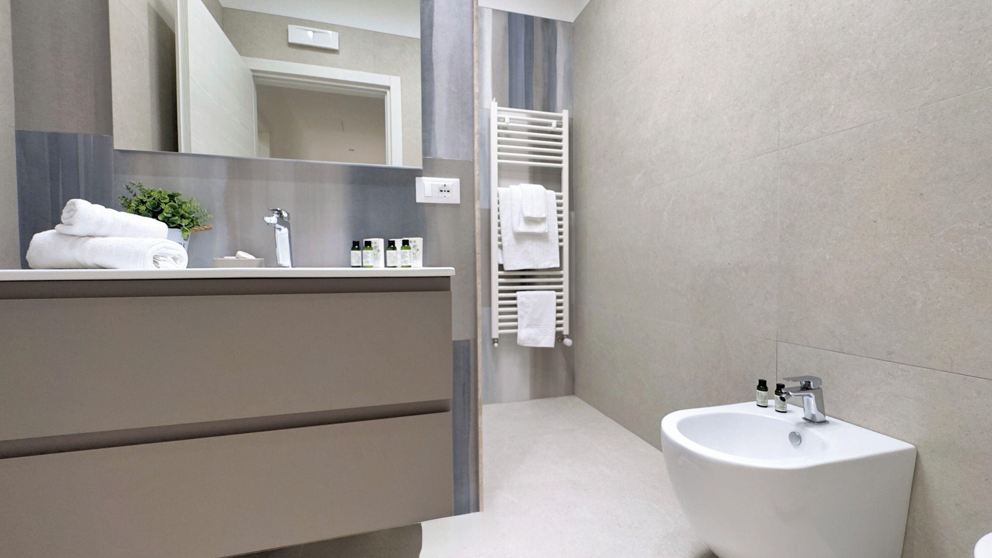 A modern bathroom with a vanity, sink, and towel rack.