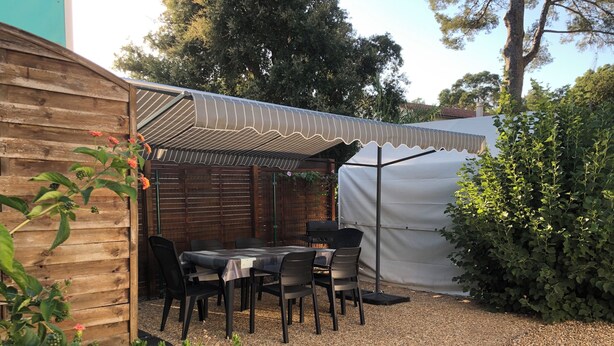 A patio with a table and chairs, a grill, and a covered area. - Mobile home near the ocean with a pool (Le Pradet)