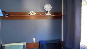 A room with two beds, a ceiling fan, a shelf with a decorative item, and a window with curtains. - Mobile home near the ocean with a pool (Le Pradet)