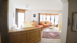 A spacious living area with a wooden bench, a sofa, and a dining table. - Adora Leukerbad # 4-bed apartment, Bad, WC by Interhome (Leukerbad)