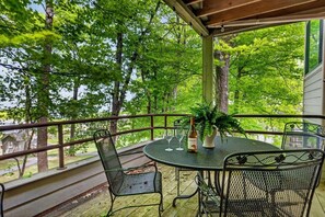 A covered outdoor area with a round table and chairs, surrounded by a railing, overlooking a wooded area. - Dobie 26 with Wintergreen Advantage (Wintergreen)