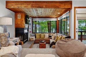 A cozy living room with a fireplace, large windows, and a comfortable seating area. - Dobie 26 with Wintergreen Advantage (Wintergreen)
