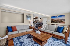 Ein modernes Wohnzimmer mit einem Ecksofa, einem Couchtisch und einem Teppich.