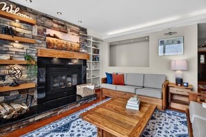 Ein modernes Wohnzimmer mit Kamin, einer Couch, einem Couchtisch und einem Bücherregal.