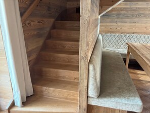 A wooden staircase with a cushioned bench at the bottom. - New Chalets in the Tannheimer Valley (Jungholz)