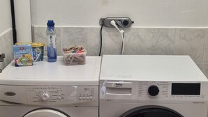 A front-loading washing machine and dryer side by side in a laundry room.